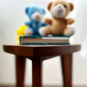 Kado ručno rađen drveni stočić od oraha sa zaobljenim gornjim delom i drvenim spojevima, prikazan u modernom enterijeru