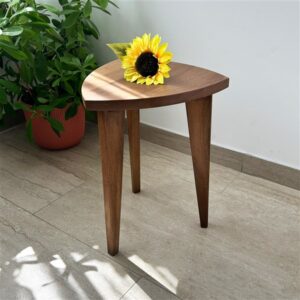 Kado ručno rađen drveni stočić od oraha sa zaobljenim gornjim delom i drvenim spojevima, prikazan u modernom enterijeru