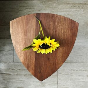 Kado ručno rađen drveni stočić od oraha sa zaobljenim gornjim delom i drvenim spojevima, prikazan u modernom enterijeru