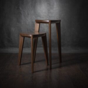 Dva ručno rađena stolčića različitih visina iz Takai seta, izrađenih od masivnog oraha, prikazani na tamnoj drvenoj podlozi.