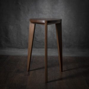 Jedan od dva ručno rađena stolčića različitih visina iz Takai seta, izrađenih od masivnog oraha, prikazan na tamnoj drvenoj podlozi.