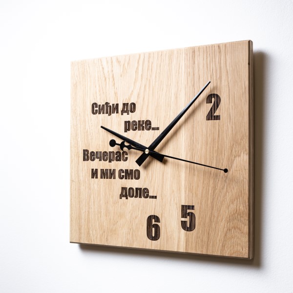 Zidni sat sa posvetom Meda furniture Drveni zidni sat sa laserskom gravurom ‘Siđi do reke večeras mi smo dole’, na belom zidu