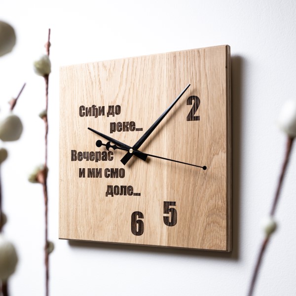 Zidni sat sa posvetom Meda furniture Drveni zidni sat sa laserskom gravurom ‘Siđi do reke večeras mi smo dole’, na belom zidu