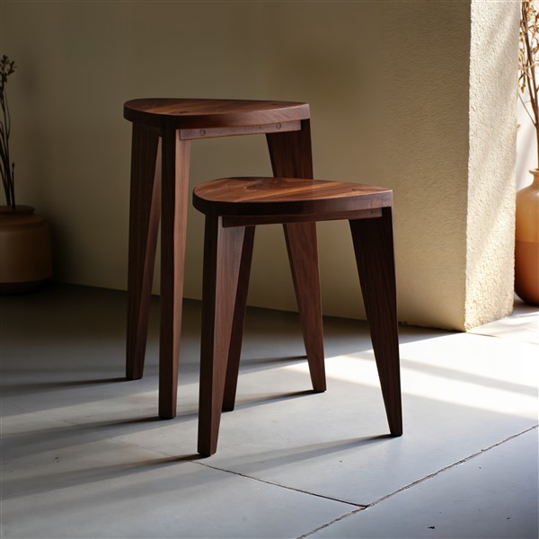 Orah tamnocrveni set Set od dve tamnocrvene hoklice od punog oraha, prikazane u svetlom minimalističkom enterijeru. Prikazuje kontrast crnog tona drveta sa čistim i jednostavnim linijama prostora.